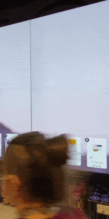 A person with a bun hairstyle moves swiftly in front of a large screen, a whirlwind of digital icons and documents taking center stage. The background is slightly blurred by motion, embodying the essence of a digital transformation strategy in action.