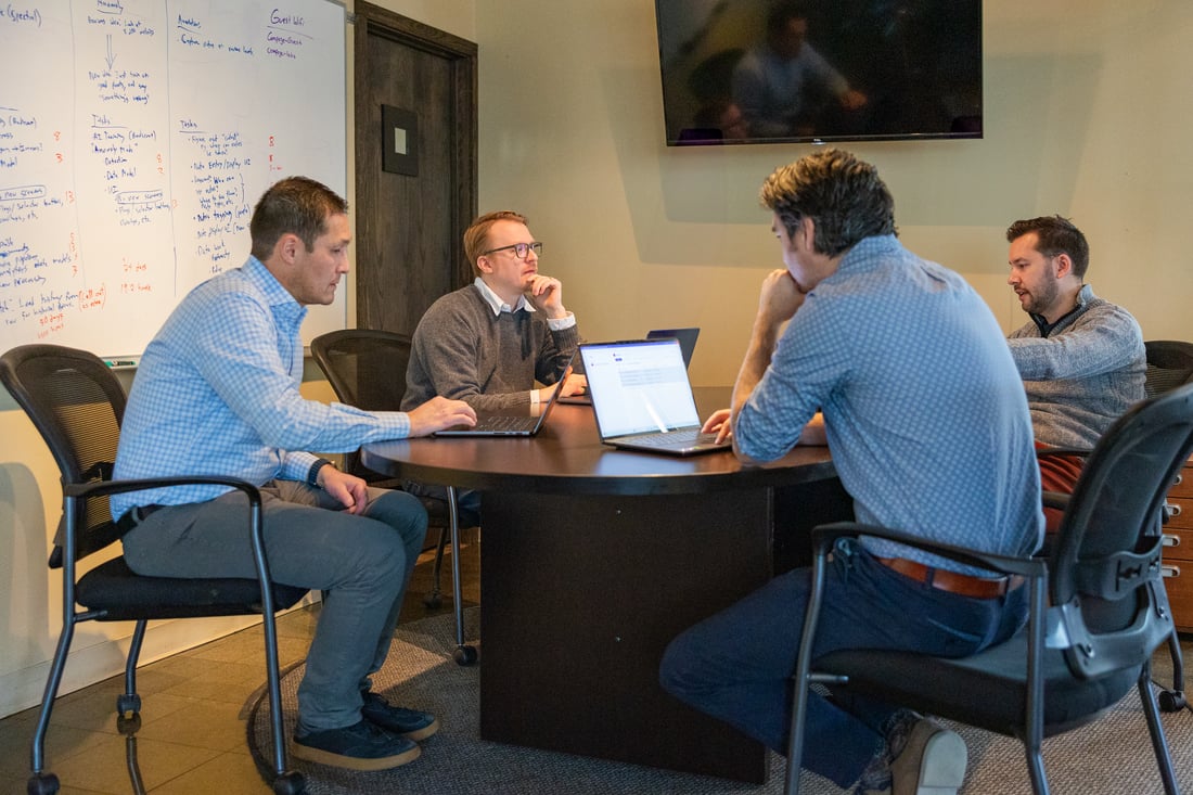 The Compoze Labs team working through a problem together at the table