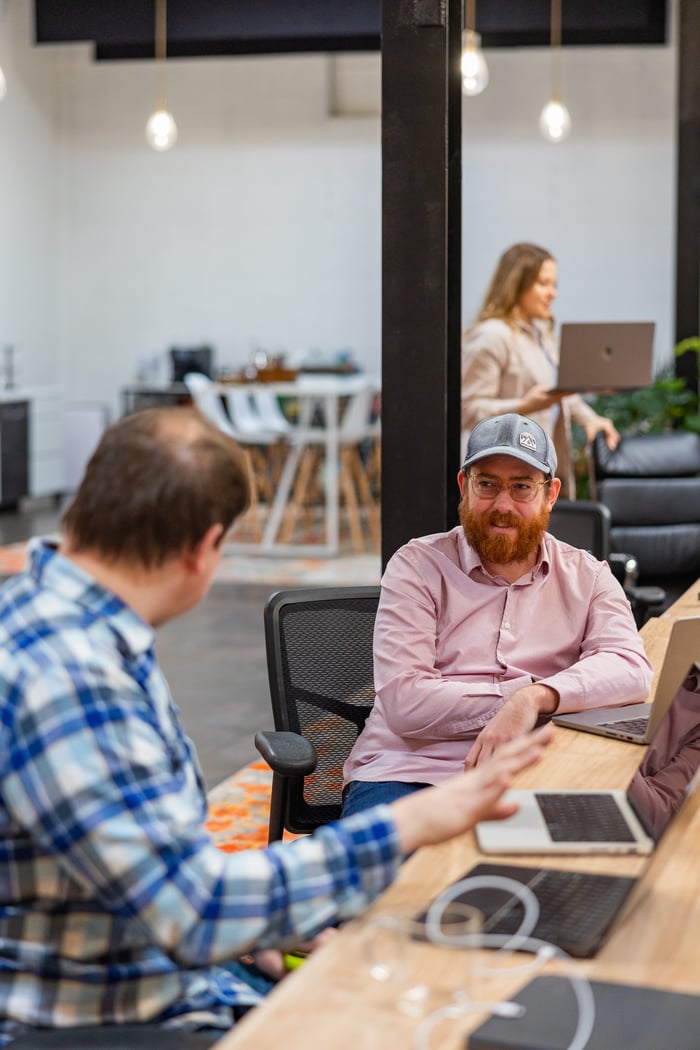 Two Compoze Labs colleagues working together at a table with laptops