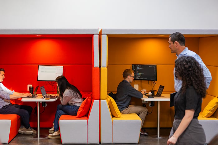 Two Compoze Labs team members talking in an orange office nook