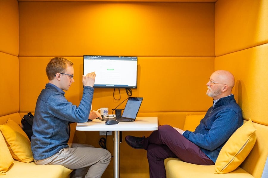Two Compoze Labs colleagues collaborating at a screen in an office nook
