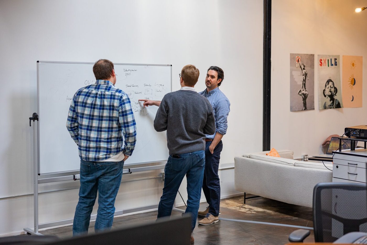 Three Compoze Labs team members planning together at a whiteboard