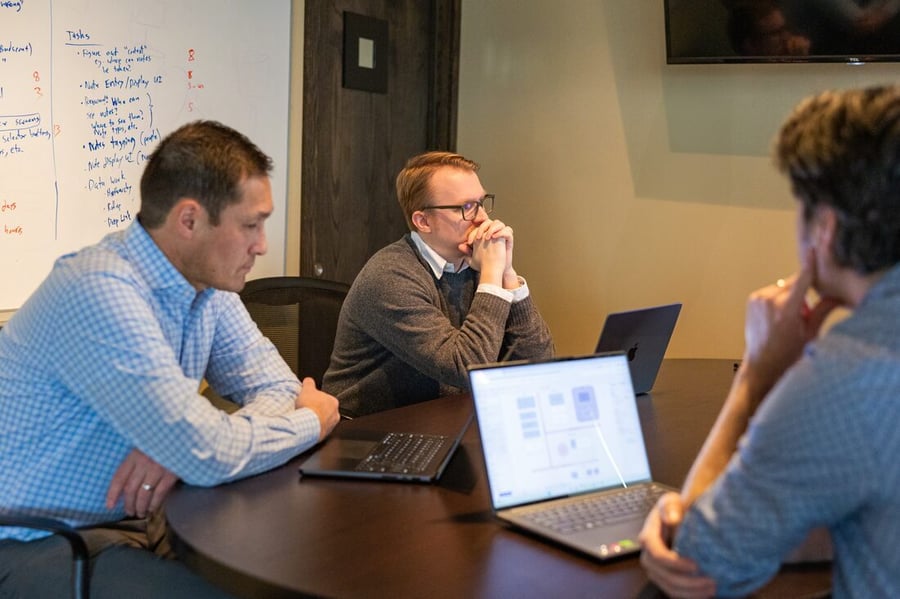 Two Compoze Labs colleagues in a focused working session at a table