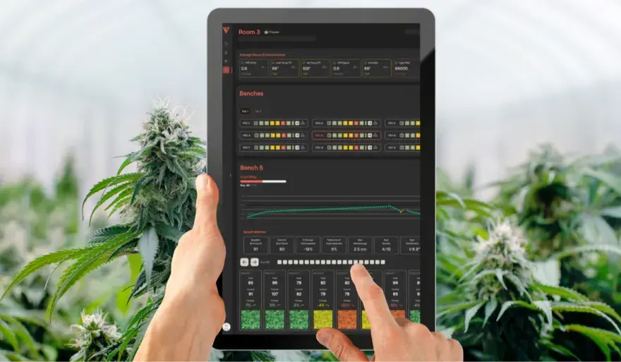 A person holds a tablet displaying a dark-themed data dashboard, likely from an MVP development project, with charts, graphs, and color-coded numeric information. One hand interacts with the interface while the other supports the device.